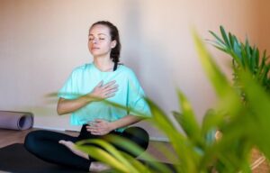 A young lady is practicing mindful exercises to manage stress for a healthy gut. Exploring the relationships between stress & exercise's role in gut function and overall well-being